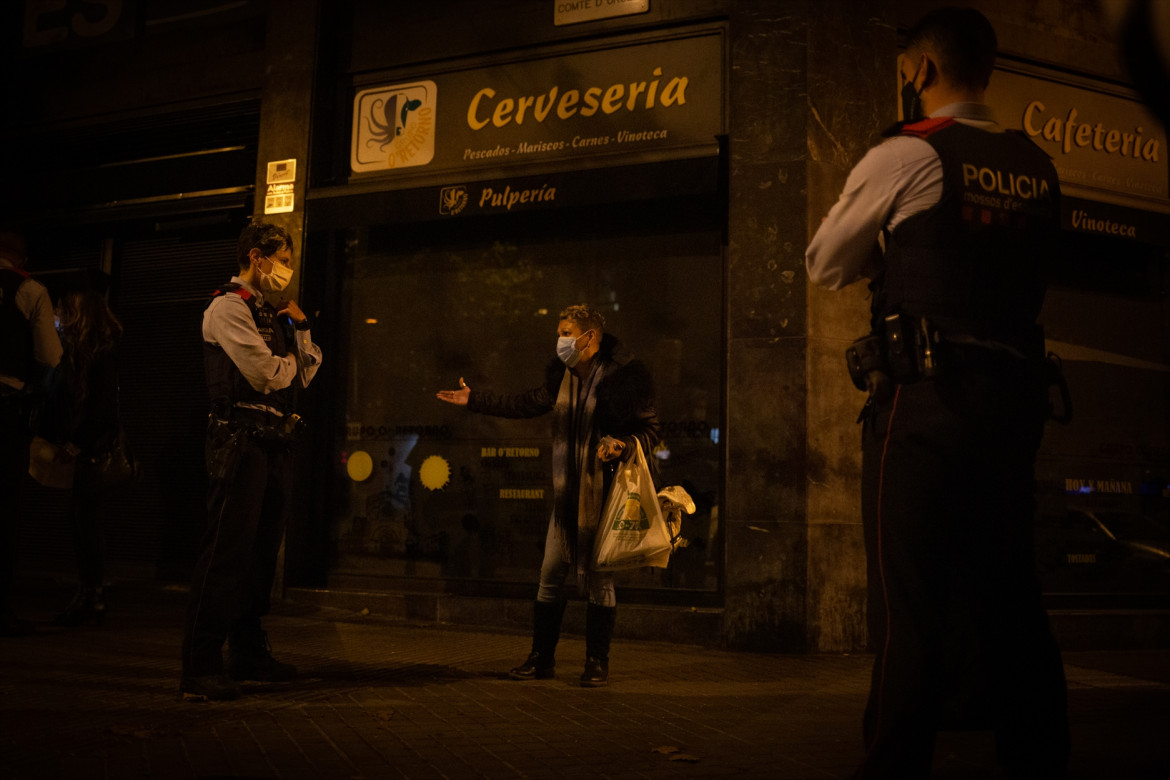 Archivo - Varios mossos d'Esquadra paran a una persona durante un control durante el toque de queda impuesto por la crisis sanitaria del Covid-19 desde las 22.00 horas a las 6.00 del día siguiente, e