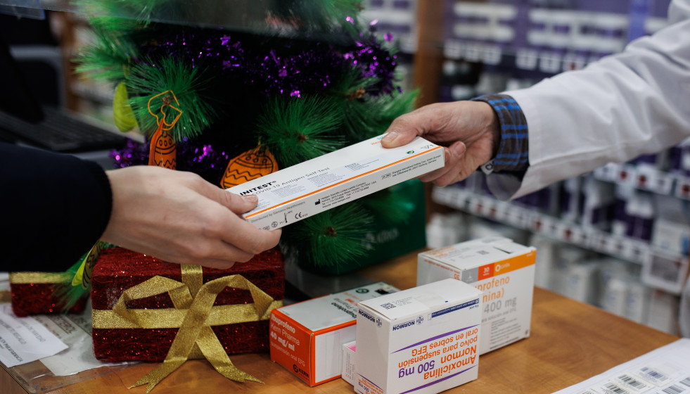 Una persona recoge en la farmacia de la Calle Tucán, en el distrito de Carabanchel, un test de antígeno gratuito, a 21 de diciembre de 2021, en Madrid (España). Todos los madrileños pueden recoger