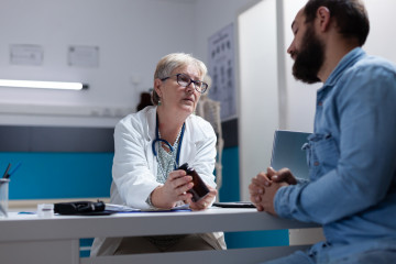 Medic holding bottle pills give sick patient checkup visit general practitioner giving jar with prescription medicine treatment healthcare support man