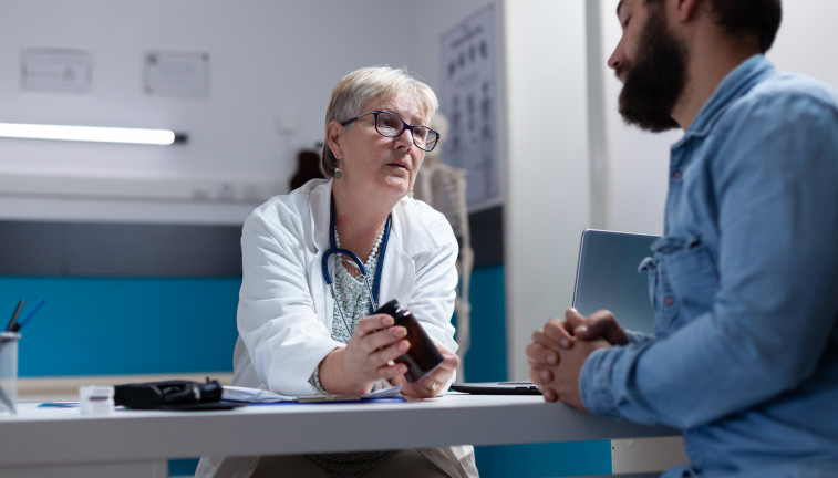 Medic holding bottle pills give sick patient checkup visit general practitioner giving jar with prescription medicine treatment healthcare support man